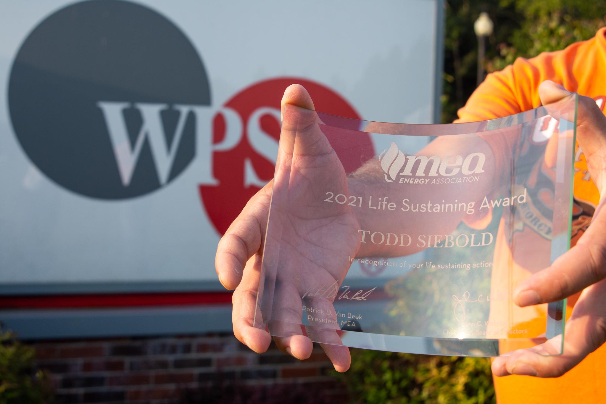 A glass award for Todd Siebold in front of a WPS sign.