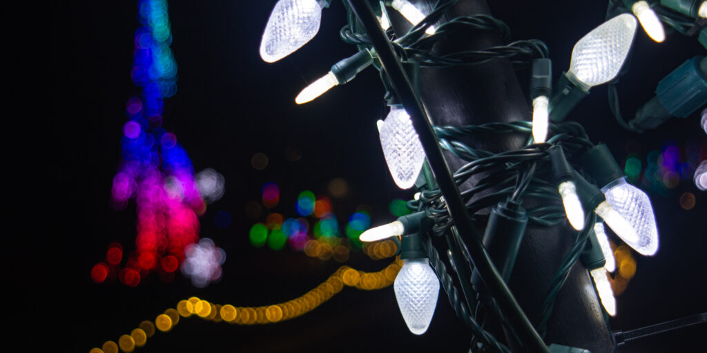 A close-up of white cone-shaped holiday lights lit up at night.