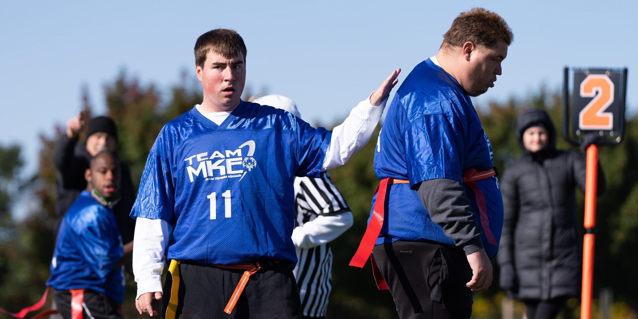 Two men in blue jerseys playing flag football.