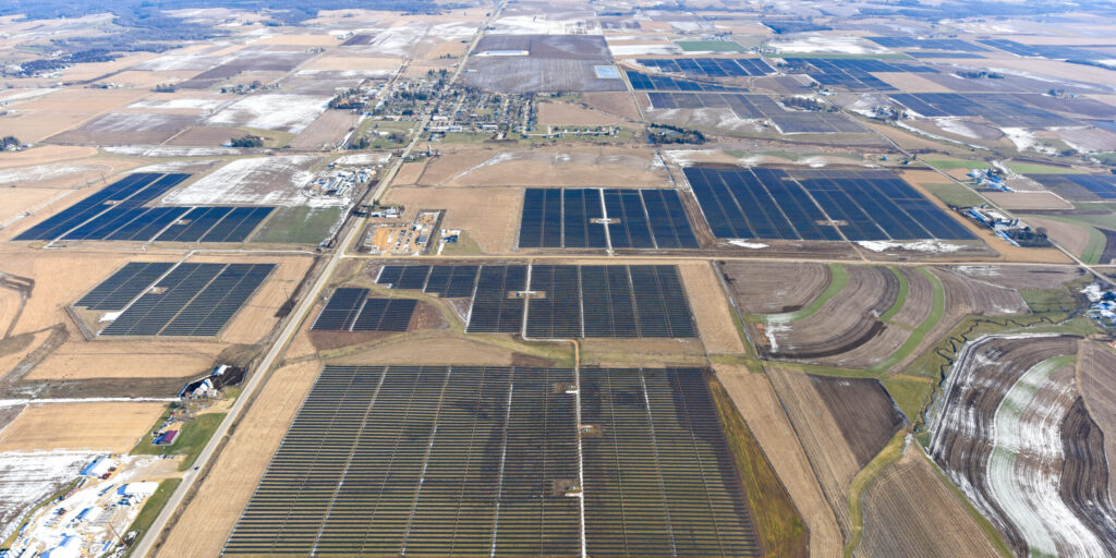 Aerial view of solar panels installed among farm fields.