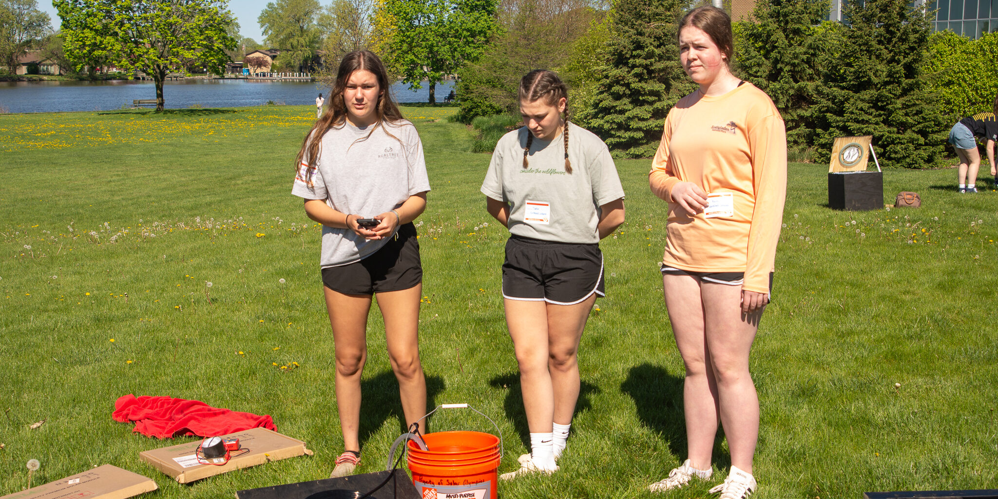 A group of high school girls discusses a solar-powered water heater during a sunny day at the Solar Olympics.