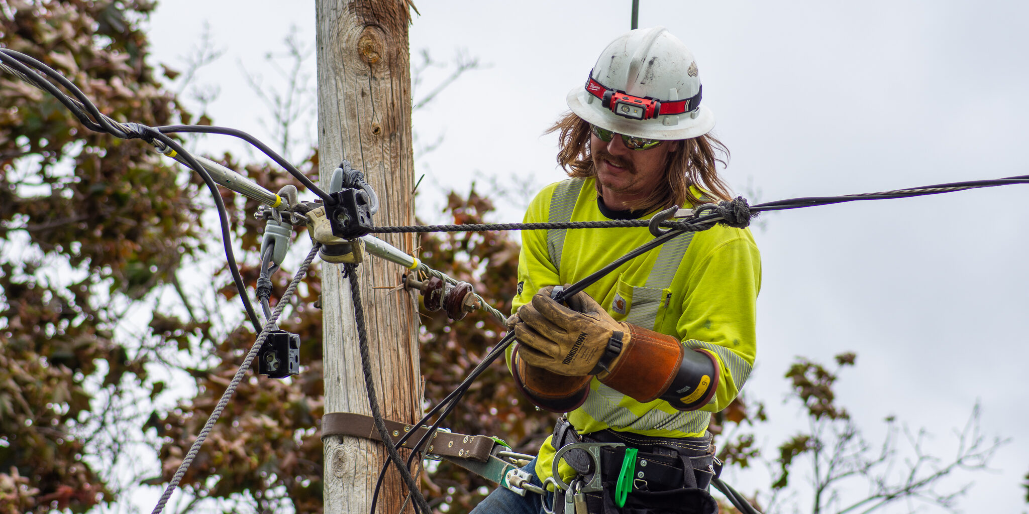 A WPS lineworker makes repairs to a power line on a utility pole.