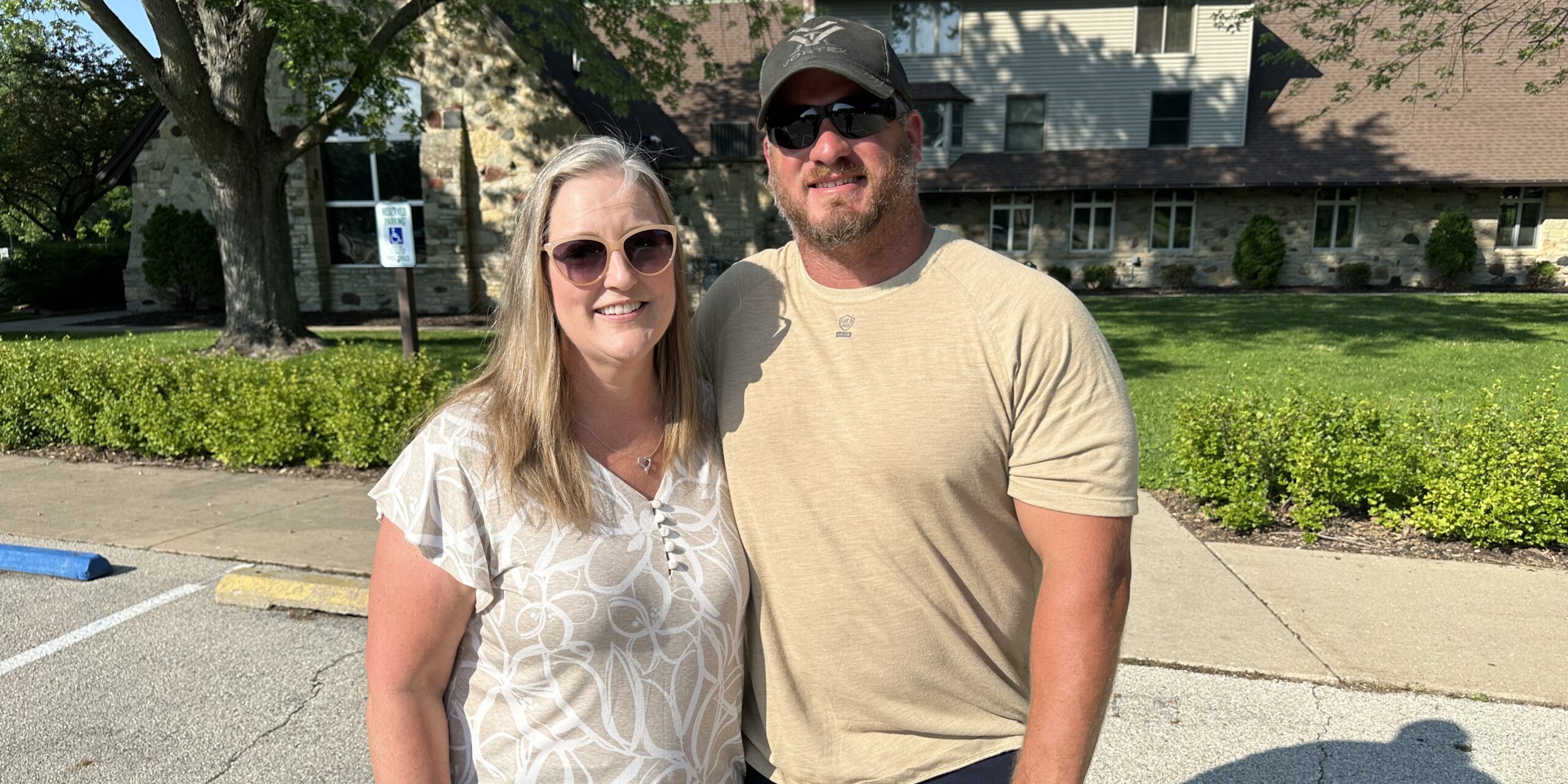 A woman and man take a photo in a park on a sunny day.