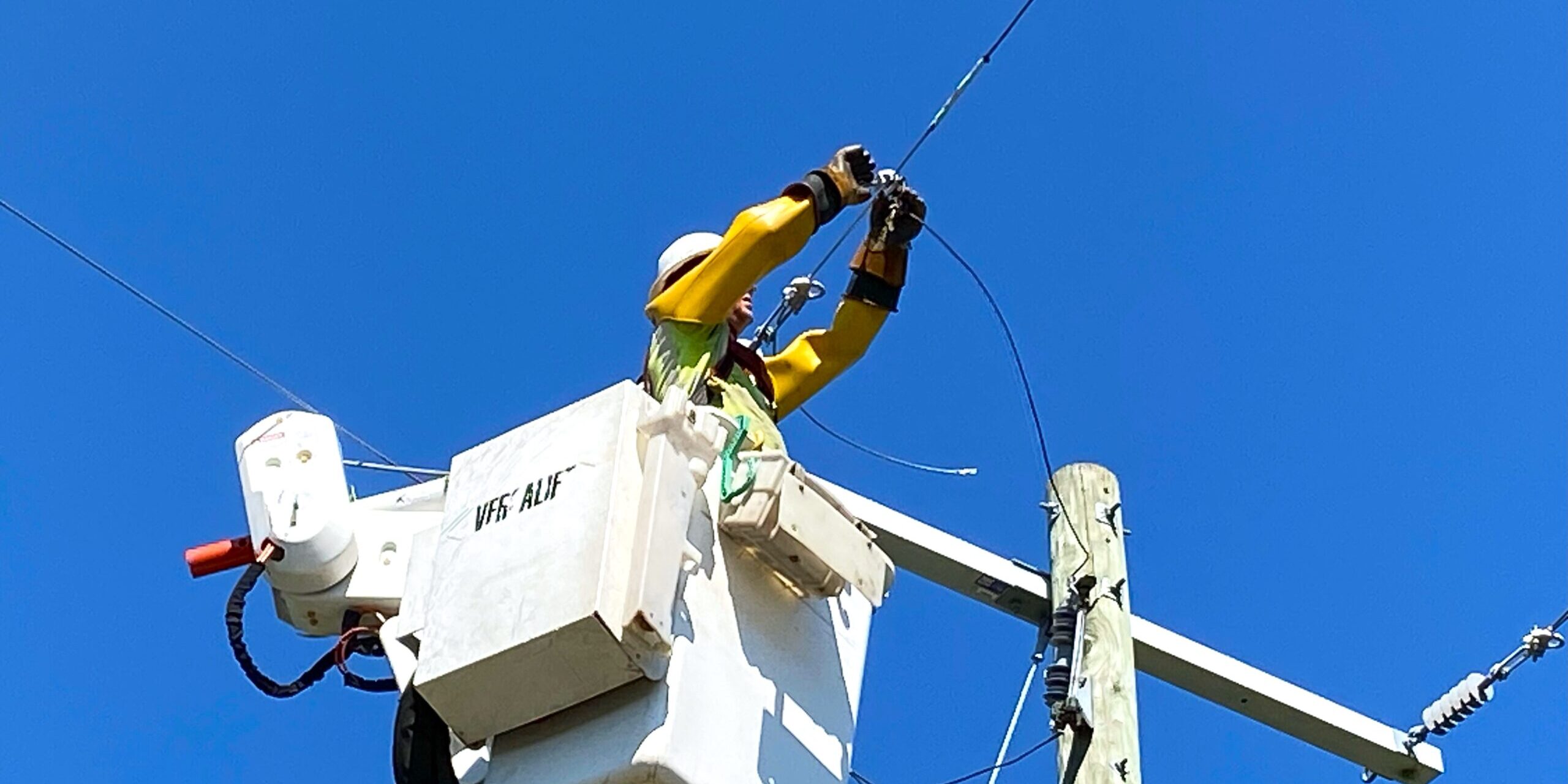 A WPS lineworker makes repairs to a power line from a bucket truck.