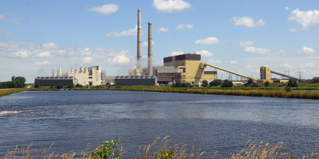 A large electric generation facility near a body of water.