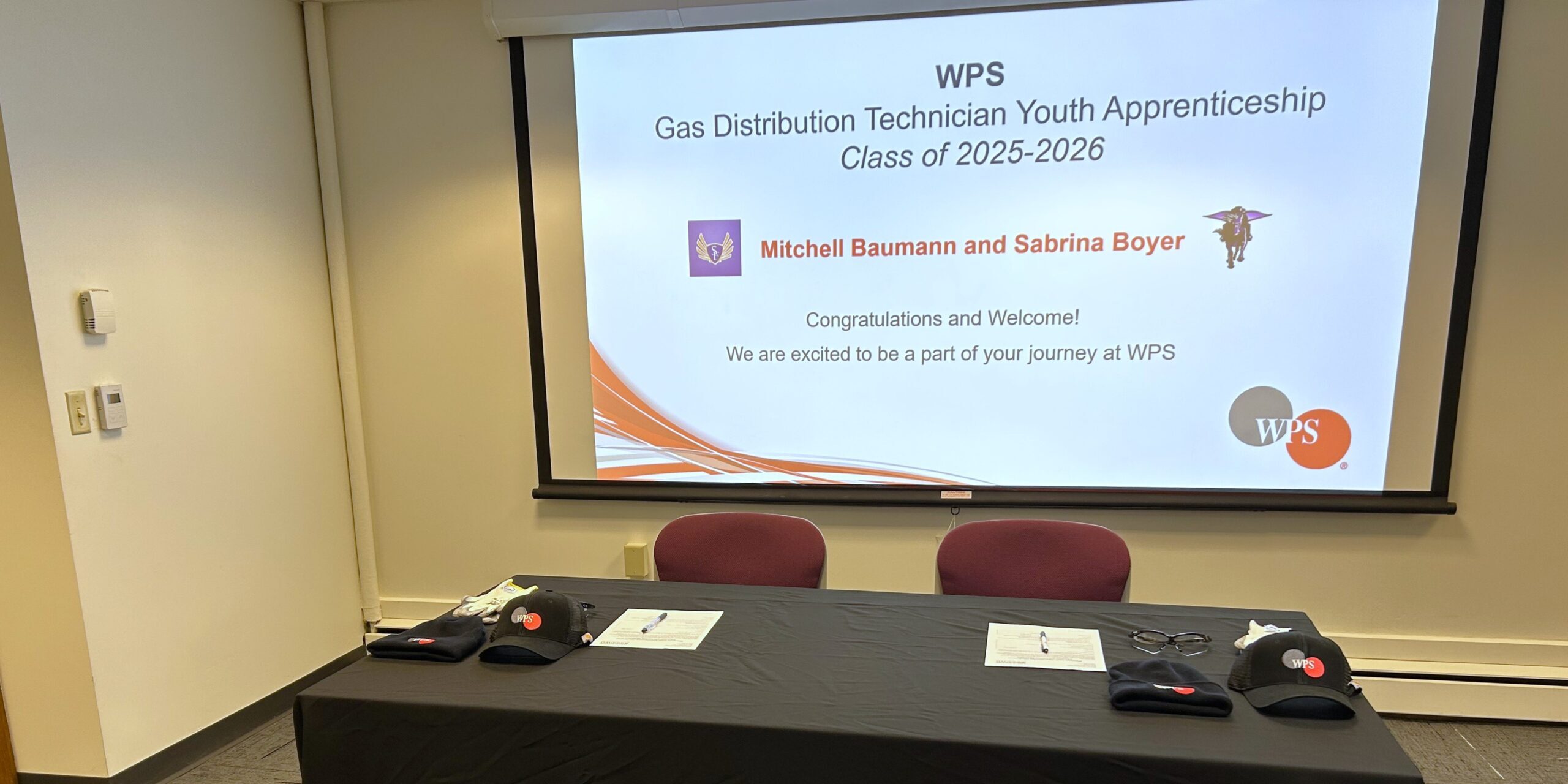 A congratulatory slide welcomes two high school students to a new WPS youth apprenticeship program.