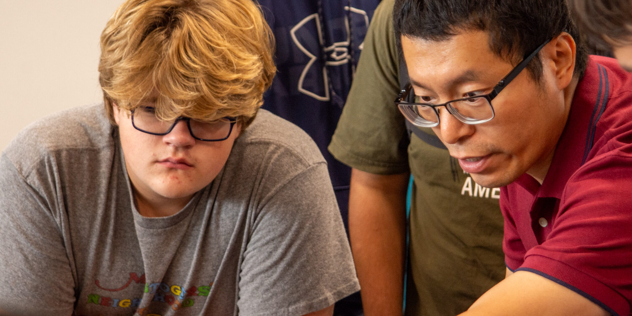 A college professor discusses a project with a high school student.