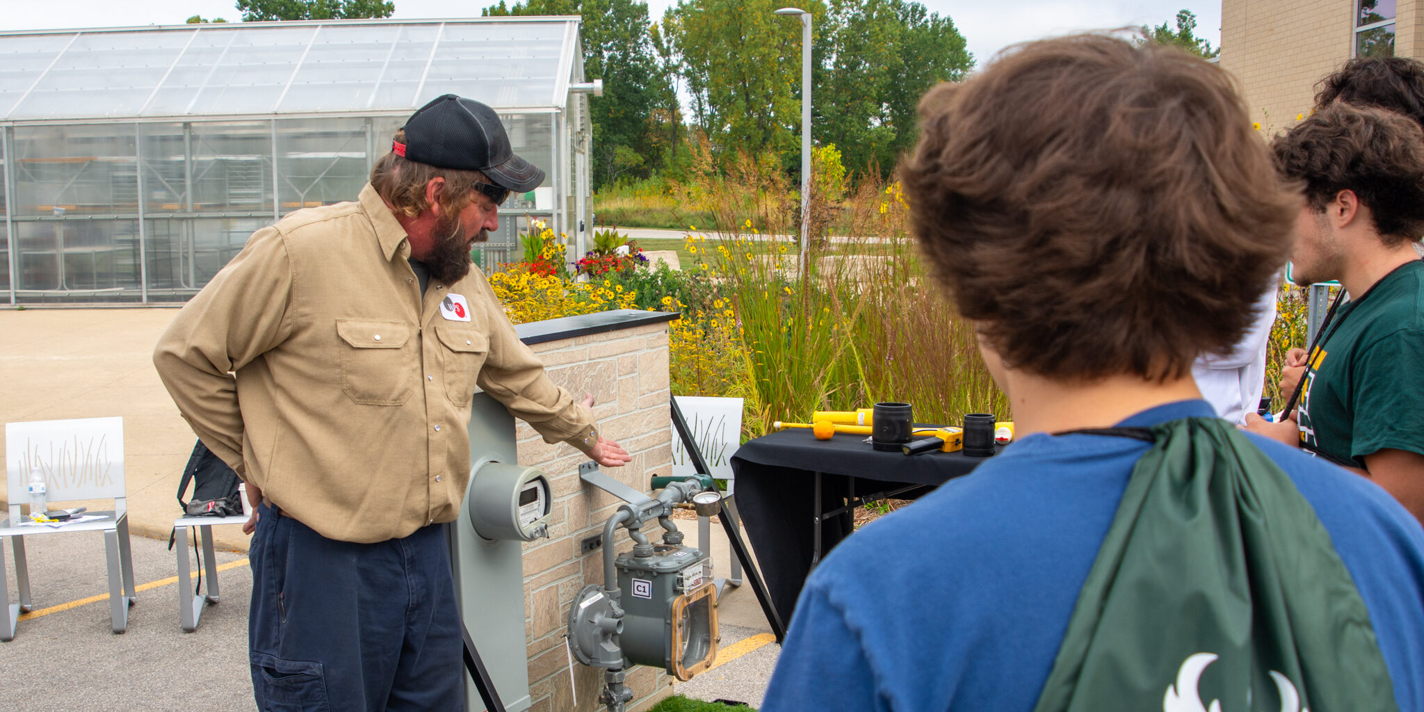 A WPS employee explains to high school students how a natural gas meter operates.