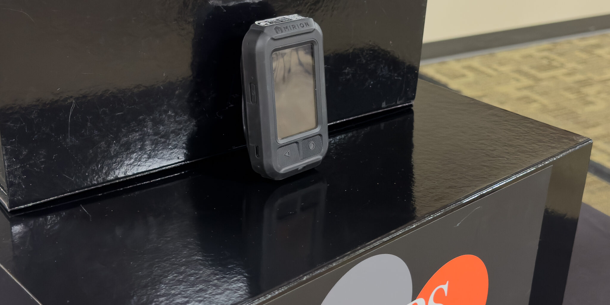 A small radiation detection device is displayed on a black box with the WPS Foundation logo on the front of it.