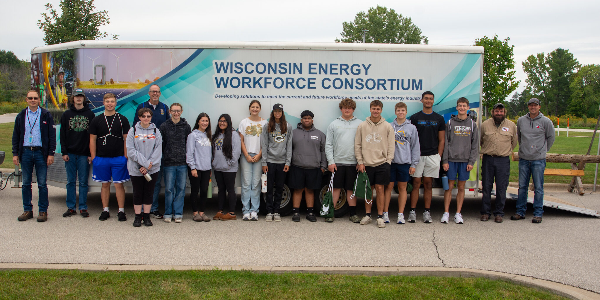WPS employees take a photo with a class of high school students in front of a Wisconsin Energy Workforce Consortium trailer.